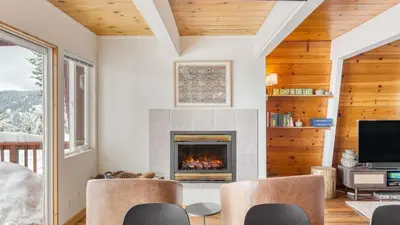 a living room with a fireplace and a tv at Chickadee by AvantStay Modern A-Frame Cabin in Tahoe City