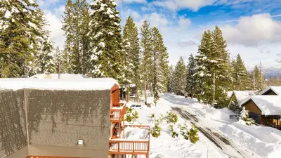 a house in the snow with snow covered trees at Chickadee by AvantStay Modern A-Frame Cabin in Tahoe City