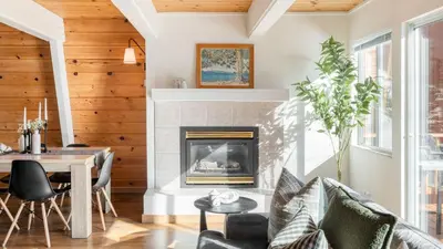 a living room with a fireplace and a table and chairs at Chickaree by AvantStay A-Frame w Mountain Views in Tahoe City