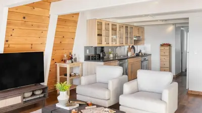a living room with two chairs and a flat screen tv at Chickaree by AvantStay A-Frame w Mountain Views in Tahoe City