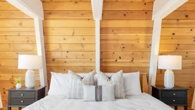 a bedroom with wooden walls and a bed with white pillows at Chickaree by AvantStay A-Frame w Mountain Views in Tahoe City