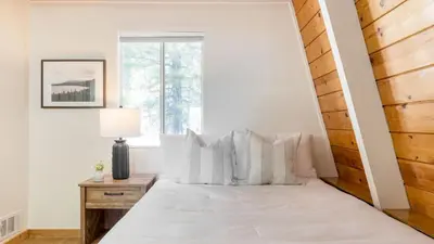 a white bedroom with a bed with white pillows at Chickaree by AvantStay A-Frame w Mountain Views in Tahoe City