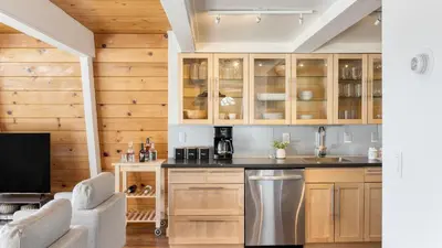 a kitchen with wooden cabinets and a sink at Chickaree by AvantStay A-Frame w Mountain Views in Tahoe City