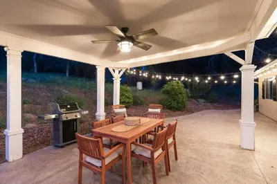 a patio with a table and chairs and a stove at Relax at Yosemite, Cozy House with King Bed, Private Hot Tub & Fast Wi-Fi, Near town in Oakhurst