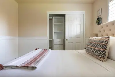 a bedroom with a white bed with a pillow on it at Relax at Yosemite, Cozy House with King Bed, Private Hot Tub & Fast Wi-Fi, Near town in Oakhurst