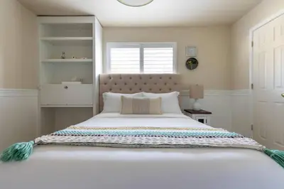 a bedroom with a large white bed with a window at Relax at Yosemite, Cozy House with King Bed, Private Hot Tub & Fast Wi-Fi, Near town in Oakhurst