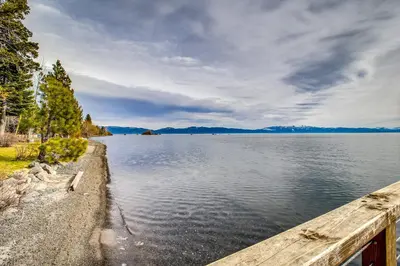 a large body of water with a wooden pier at Talmont Trailhead Cabin in Tahoe City