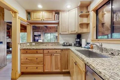 a kitchen with wooden cabinets and a sink at Talmont Trailhead Cabin in Tahoe City