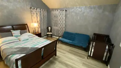 a bedroom with a bed and a blue couch at Beautiful peaceful desirable home in Madera Rancho in Madera