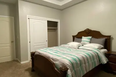 a bedroom with a bed with a striped comforter at Beautiful peaceful desirable home in Madera Rancho in Madera