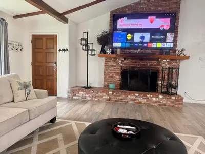 a living room with a fireplace and a tv at The Happy Cabin w/ hot tub in Oakhurst