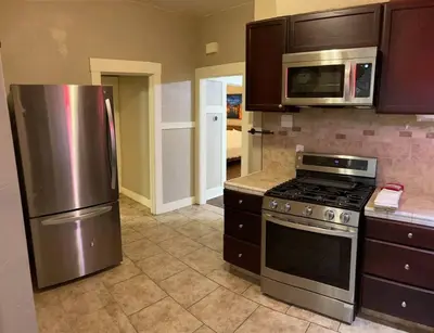 a kitchen with a stainless steel refrigerator and microwave at 2 King Beds! Fantastic Stylish Bungalow home! in Fresno