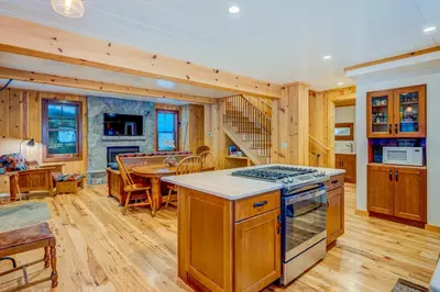a kitchen and dining room with a stove and a table at A Bear's Rest in Homewood