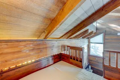 a small room with wooden walls and a bed at Rocky Revival in Truckee