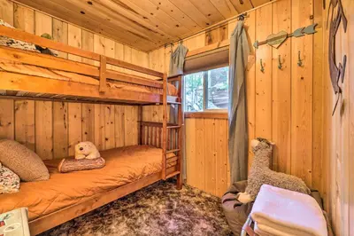 a bedroom with two bunk beds in a log cabin at California Retreat with Deck, Fire Pit and Grill! in Long Barn