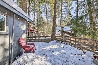 a red chair sitting on a porch in the snow at California Retreat with Deck, Fire Pit and Grill! in Long Barn