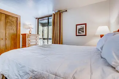 a bedroom with a large white bed and a window at Silver Strike Serenity in Truckee