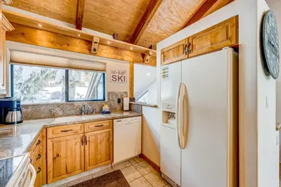 a kitchen with wooden cabinets and a refrigerator at The Pines at Rocky Point in Truckee