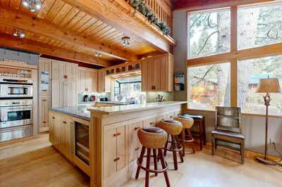 a kitchen with wooden cabinets and a counter with stools at A Slice of Silver Fir in Truckee