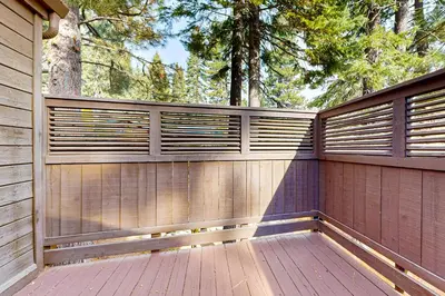 a wooden fence on a wooden deck with trees at A Slice of Silver Fir in Truckee