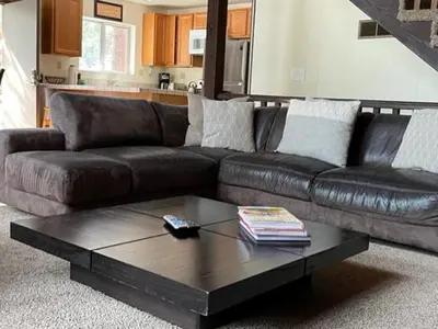 a brown leather couch with a coffee table in a living room at Close To Heaven With Hot Tub, Wet Bar & Game Room in South Lake Tahoe