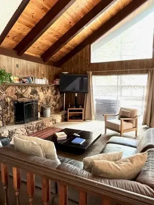 a living room with a couch and a tv at Close To Heaven With Hot Tub, Wet Bar & Game Room in South Lake Tahoe