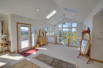 a living room with a mirror and a balcony at Enviable Lake & Mountain Views Wth Waterfall in South Lake Tahoe
