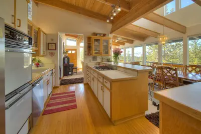 a large kitchen with white appliances and a dining room at Enviable Lake & Mountain Views Wth Waterfall in South Lake Tahoe