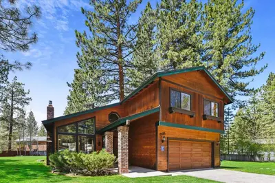 a wooden house with a garage at Minutes From Heavenly Valley & Lake Tahoe Beaches in South Lake Tahoe