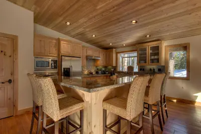 a kitchen with a large island with bar chairs at Brand New Upscale Home, Hot Tub, Foosball in South Lake Tahoe
