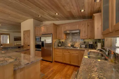 a kitchen with wooden cabinets and stainless steel appliances at Brand New Upscale Home, Hot Tub, Foosball in South Lake Tahoe