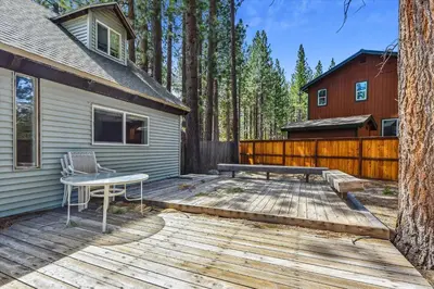 a wooden deck with a table and a house at Newly Renovated, Foosball Table in South Lake Tahoe
