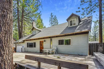 a house with a wooden deck in the woods at Newly Renovated, Foosball Table in South Lake Tahoe