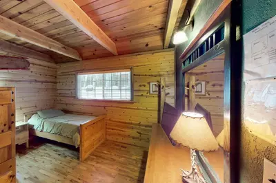 a log cabin with a bed and a window at Walkup Pines in South Lake Tahoe