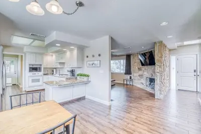 a kitchen and dining room with white cabinets and a table at X-Large Spacious Deluxe House Fastest Wi-Fi in Fresno