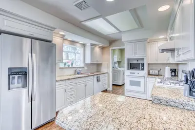 a kitchen with white cabinets and a refrigerator at X-Large Spacious Deluxe House Fastest Wi-Fi in Fresno