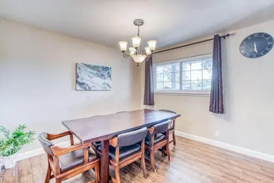 a dining room with a table and chairs and a clock at X-Large Spacious Deluxe House Fastest Wi-Fi in Fresno