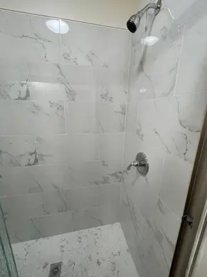a bathroom with a shower with a glass door at Brand New 2BR CUTE Blue LED in North Fresno in Fresno