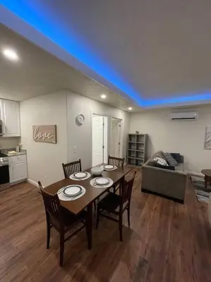 a living room with a table and chairs and a couch at Brand New 2BR CUTE Blue LED in North Fresno in Fresno
