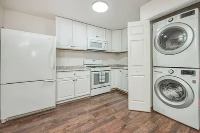 a kitchen with white cabinets and a washer and dryer at Totally New Awesome North Fresno Back Studio in Fresno