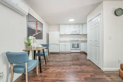 a kitchen with white cabinets and a table and chairs at Totally New Awesome North Fresno Back Studio in Fresno
