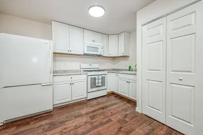 a kitchen with white cabinets and a white refrigerator at Totally New Awesome North Fresno Back Studio in Fresno
