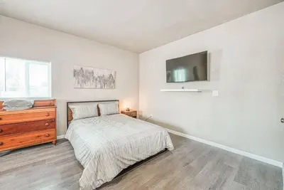 a bedroom with a bed and a dresser and a television at Stylish Studio 89 Brand New from the floor up in Fresno