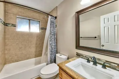 a bathroom with a sink and a toilet and a mirror at Lake Views in 3bdr Family Home w/ Hottub in South Lake Tahoe