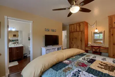 a bedroom with a bed and a flat screen tv at Yosemite Corner w NEW game room/Hot Tub/EV more in Oakhurst