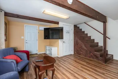 a living room with a couch and a tv and stairs at Yosemite Corner w NEW game room/Hot Tub/EV more in Oakhurst