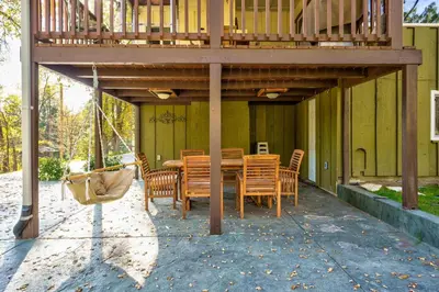 a deck with a table and chairs on a house at Yosemite Corner w NEW game room/Hot Tub/EV more in Oakhurst