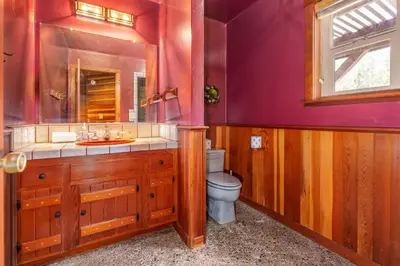 a bathroom with a toilet and a sink and a mirror at Goldside Mansion w/sleeping for 20 and tons of fun in Oakhurst