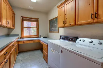 a kitchen with white appliances and wooden cabinets at Willow Cove Lodge- 5 bedrooms with a hot tub in Bass Lake