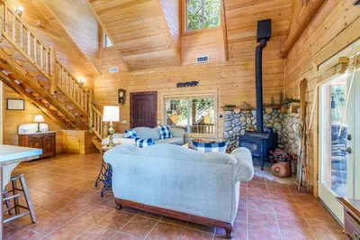 a living room with a couch and a stove at Bass Lake Log Home - Dog Friendly in Bass Lake